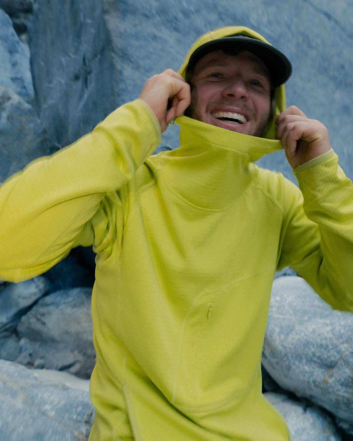 Pulling up the hood of an Air-Grid Fleece in Kepler Moss