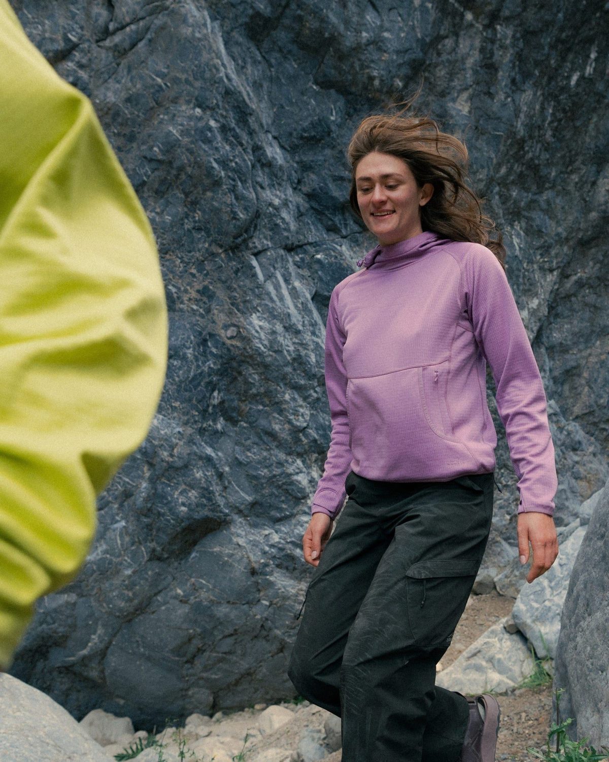 Walking through the rocks in an Air-Grid Fleece in Dusky Lavender and Overland Pants