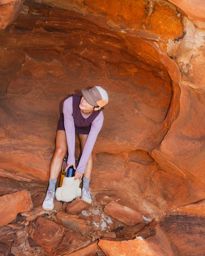 Hiker scrambling over red rock in the Daylight™ Motion Dress