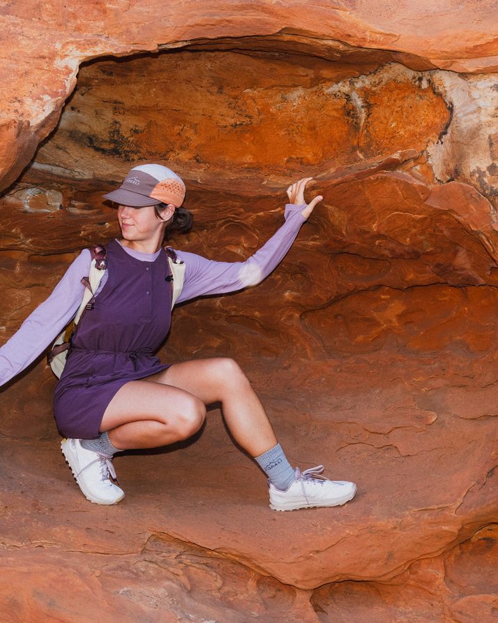 Hiker crouched in a rock hollow in the Daylight™ Motion Dress
