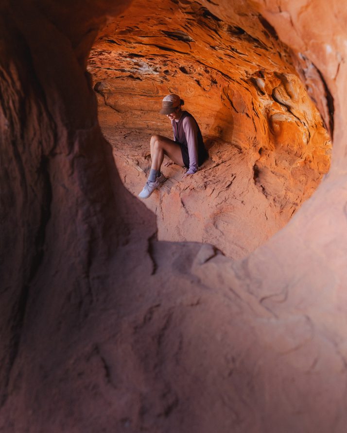 Hiker seated deep in a narrow sandstone gorge in the Daylight™ Motion Dress