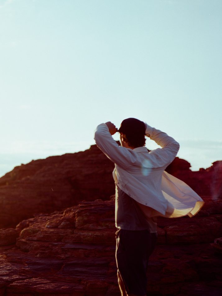 Hiker on red rock at Kings Canyon, the Beachwood Daylight™ shirt catching the wind