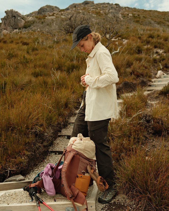 Elise buttoning the Beachwood Daylight™ Technical Long Sleeve Shirt on the track