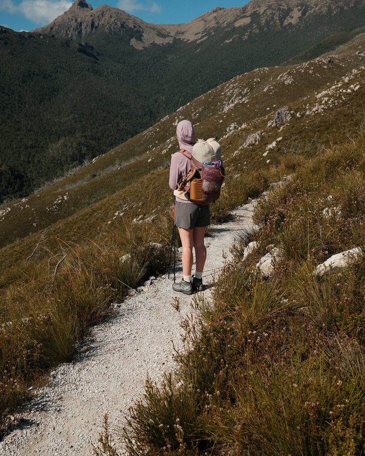 Elise walking the track with the mountains behind