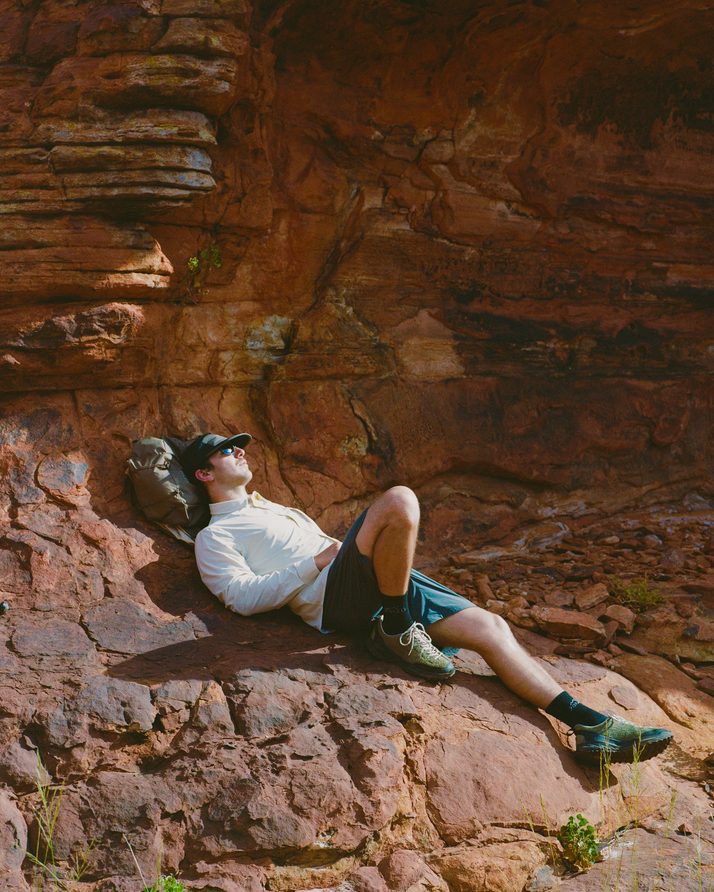 Hiker resting on warm red rock at Kings Canyon