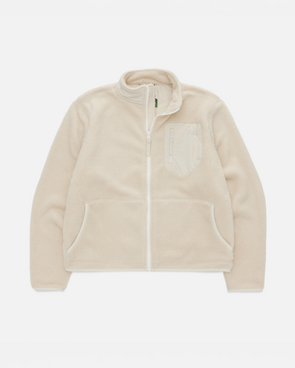 A light beige fleece zip-up jacket with a stand-up collar, a front zipper, a chest pocket with a tonal embroidered logo, and two front hand pockets, shown on a plain white background.