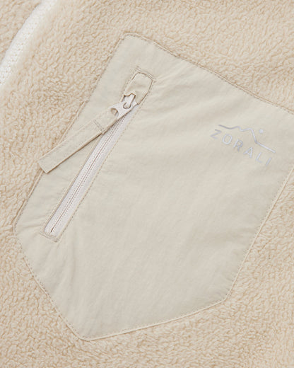 Close-up of the cream chest pocket detail on a Cosy Camp fleece jacket, showing the Zorali logo.