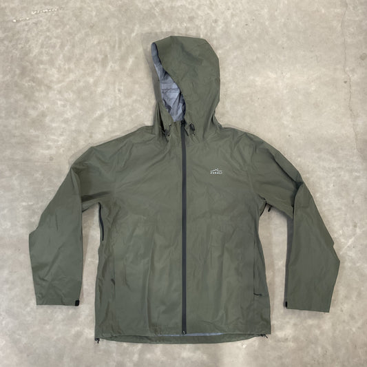 Green jacket with black zipper on a gray concrete floor