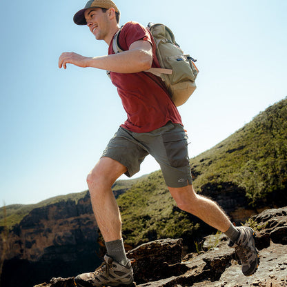 Man hiking on a rocky trail with a backpack