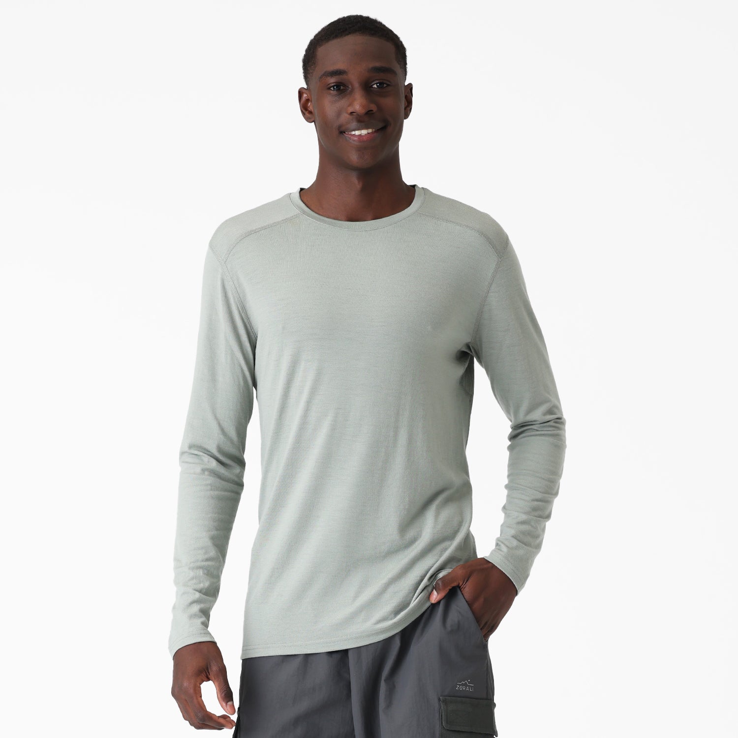 Man wearing a light green long-sleeve Merino shirt on a white background