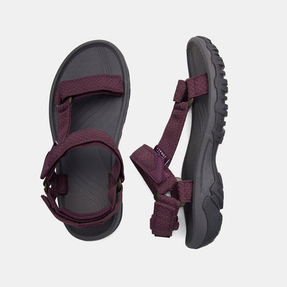 Pair of sandals with purple straps on a light gray background
