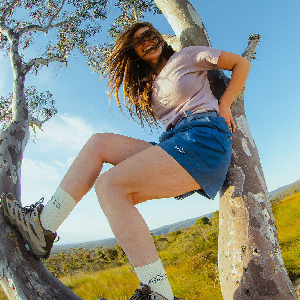 Person sitting in a tree with a scenic background