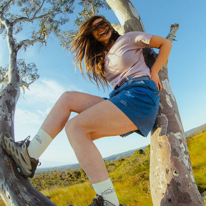 Person sitting in a tree with a scenic background