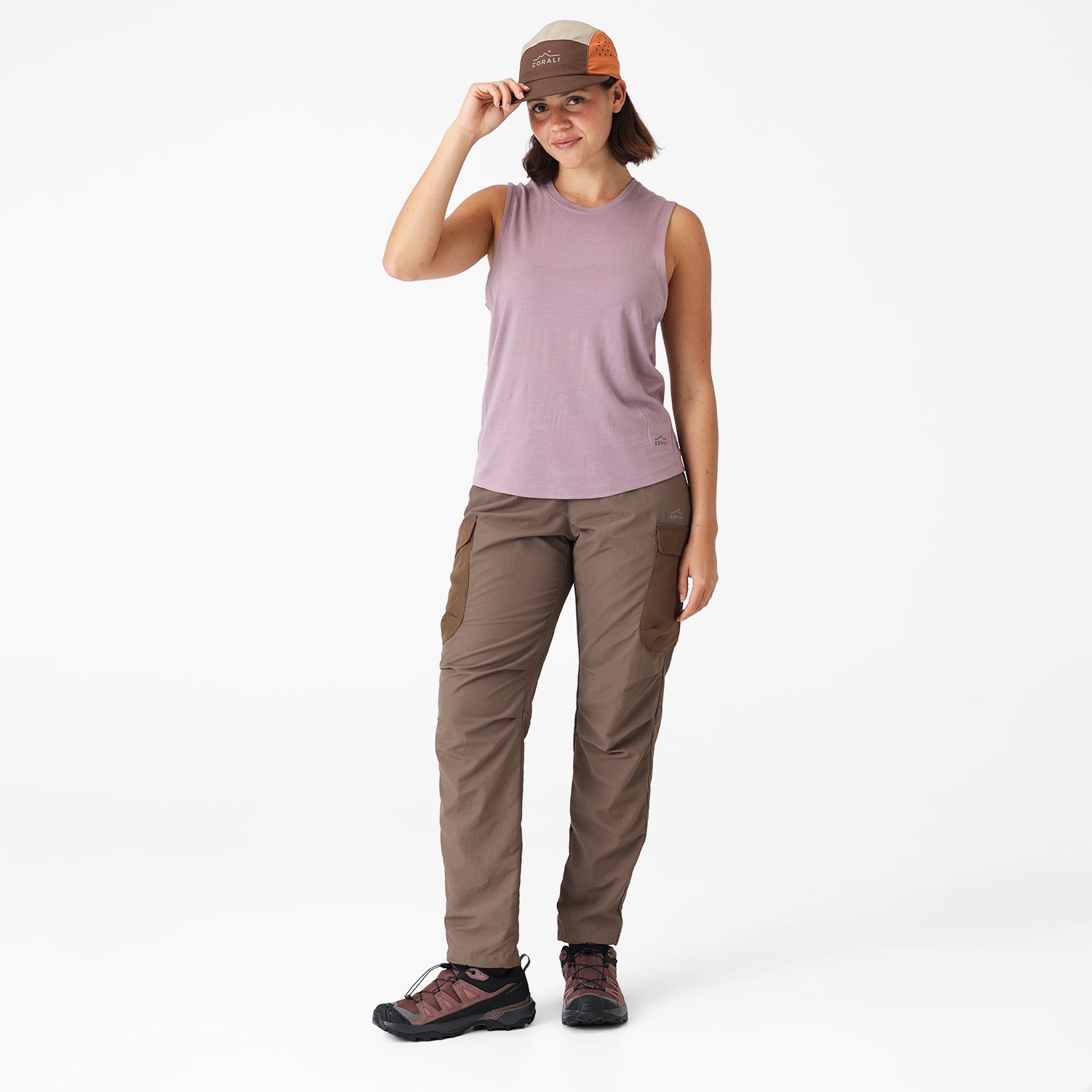 Woman wearing a sleeveless top and cargo pants on a white background