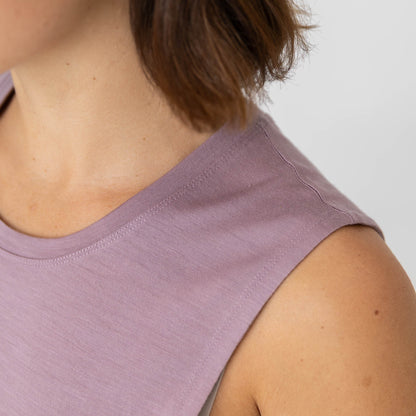 Close-up of a person wearing a light purple sleeveless top against a neutral background