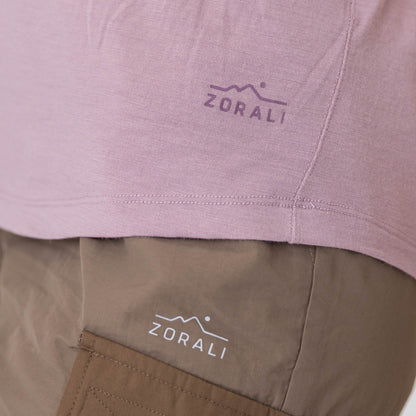 Close-up of a pink shirt and brown pants with ZORALI logo on clothing.
