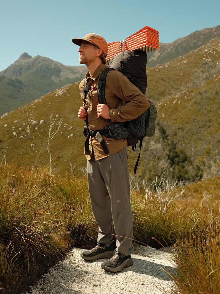 Cam on a sunny ridge with his pack in the Teak Daylight™ Technical Long Sleeve Shirt