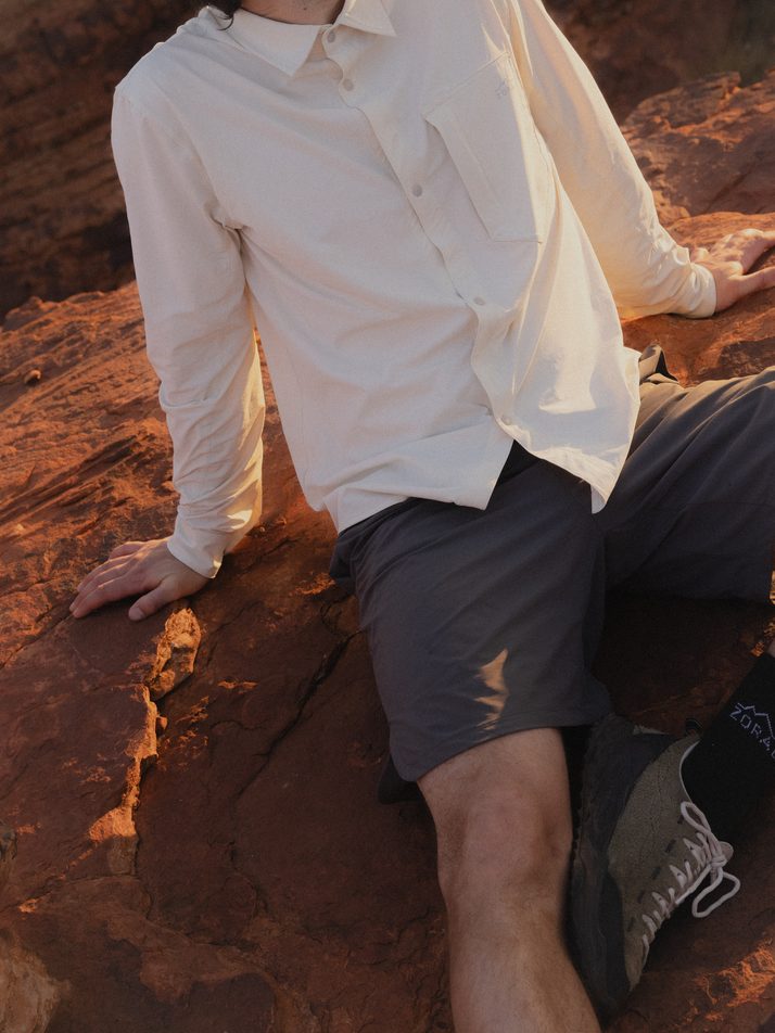 Hiker seated on red sandstone in Daylight™ Shorts in Ash