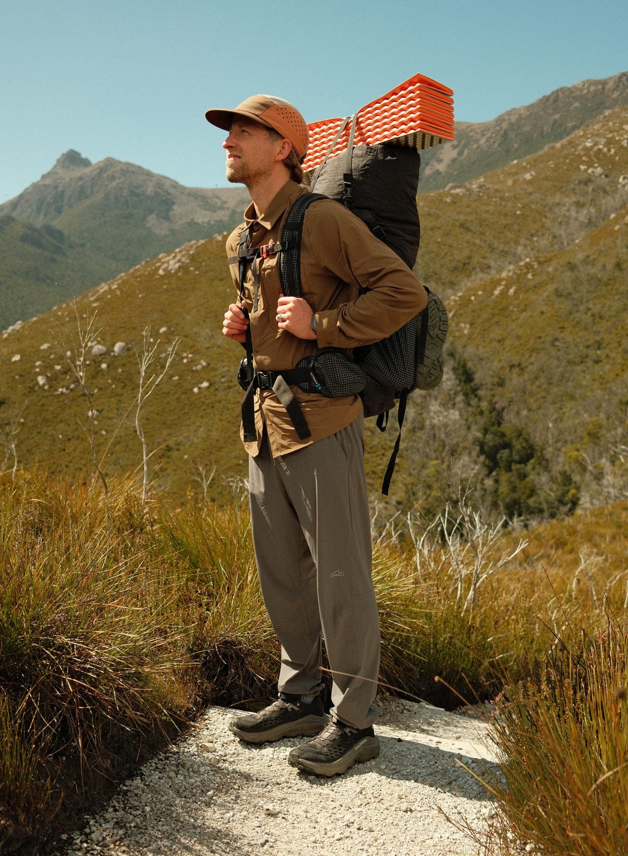 Cam on a sunny ridge with his pack in the Teak Daylight™ Technical Long Sleeve Shirt