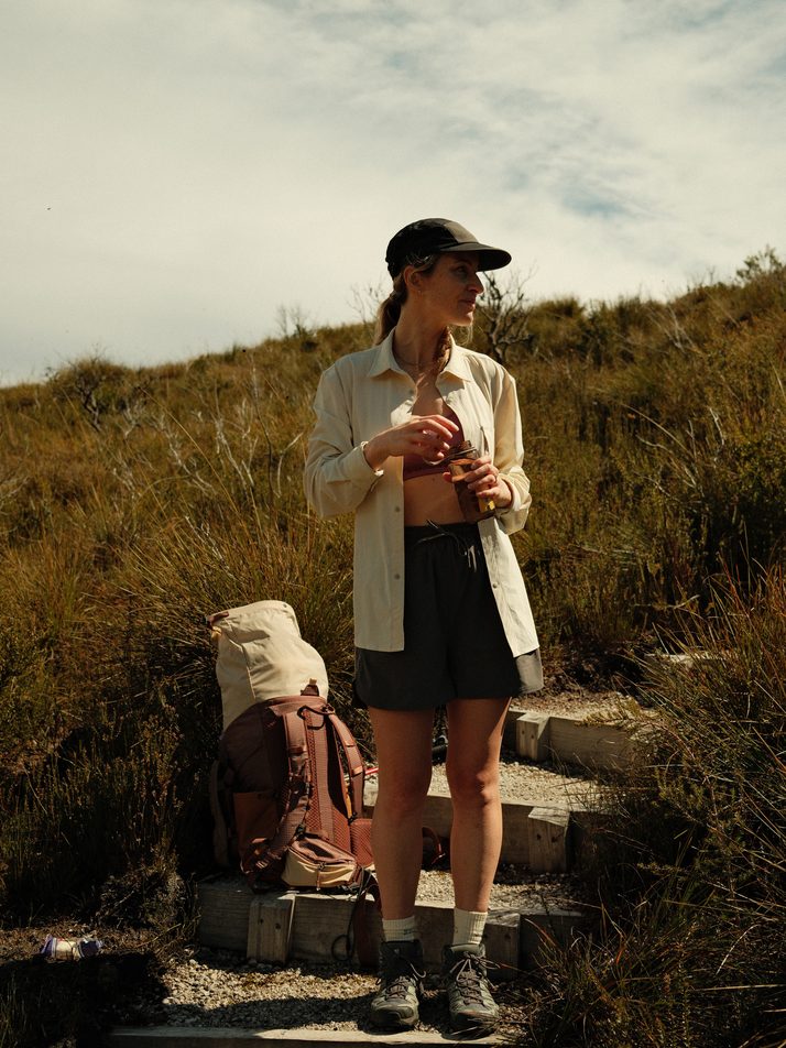 Elise on rocky steps in the Beachwood Daylight™ Technical Long Sleeve Shirt, worn open