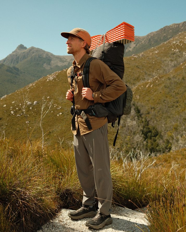 Cam on a sunny ridge with his pack in the Teak Daylight™ Technical Long Sleeve Shirt
