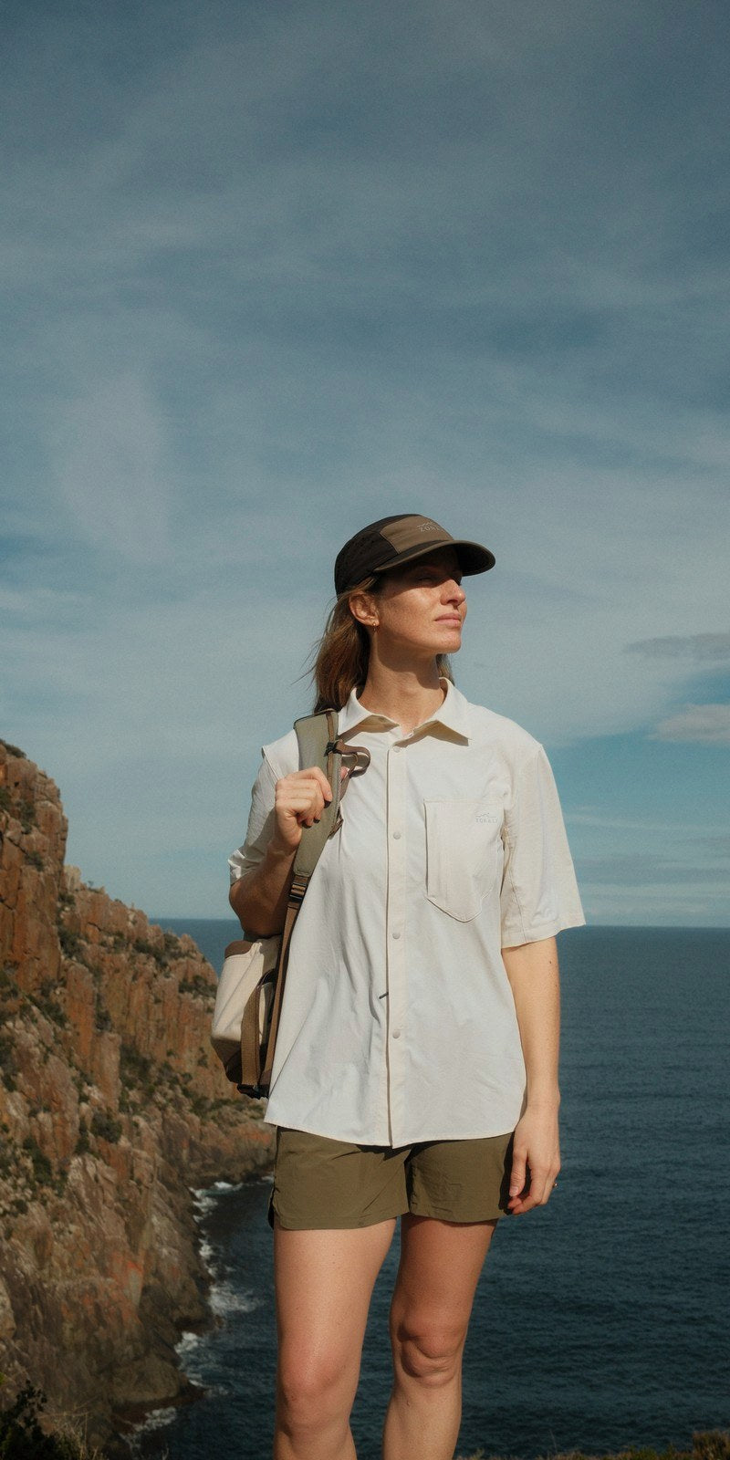 Elise on the Three Capes sea cliffs in the Beachwood Daylight™ Short Sleeve Shirt and Daylight™ Shorts